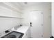 Bright laundry room features white cabinets, shelving, and a new washer and dryer at 705 W Country Estates Ave, Gilbert, AZ 85233