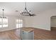 Open-concept living room features wood look flooring, neutral colored walls, and an island with butcher block countertop at 705 W Country Estates Ave, Gilbert, AZ 85233