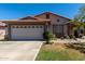 Single-story home with front lawn, two car garage, terracotta tile roof, and desert-style landscaped garden at 7403 W Montebello Ave, Glendale, AZ 85303