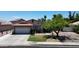 Inviting single-story home featuring a two-car garage, manicured lawn, and mature landscaping at 7403 W Montebello Ave, Glendale, AZ 85303