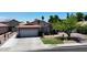Inviting single-story home featuring a two-car garage, manicured lawn, and mature landscaping at 7403 W Montebello Ave, Glendale, AZ 85303