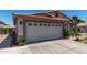 Home's two car garage with terracotta tile roof, stucco, and desert landscaping and hardscape at 7403 W Montebello Ave, Glendale, AZ 85303