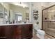 Bathroom features dark wood cabinets, double sinks, granite counters, and tiled shower at 7726 E Baseline Rd # 125, Mesa, AZ 85209