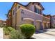 Inviting townhouse featuring a two-car garage, manicured shrubs, and modern architectural details at 7726 E Baseline Rd # 125, Mesa, AZ 85209