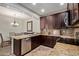 Well-equipped kitchen with granite countertops, stainless steel appliances, and dark wood cabinets at 7726 E Baseline Rd # 125, Mesa, AZ 85209