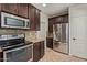 Modern kitchen featuring stainless steel appliances, granite countertops, and dark wood cabinetry at 7726 E Baseline Rd # 125, Mesa, AZ 85209