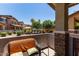 Charming outdoor patio area with comfortable seating, offering a lovely view of the community pool and landscaping at 7726 E Baseline Rd # 125, Mesa, AZ 85209