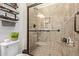 Tiled shower with a glass door, handrails, and a built in shelf at 7726 E Baseline Rd # 125, Mesa, AZ 85209