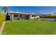 Expansive backyard with a lush lawn, covered patio, outdoor kitchen, and pool, perfect for outdoor enjoyment at 8708 E Rancho Vista Dr, Scottsdale, AZ 85251