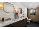 Modern bathroom showcasing double sinks, marble countertops, decorative gold sconces, and a glass-enclosed shower at 8708 E Rancho Vista Dr, Scottsdale, AZ 85251
