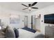 Bright bedroom featuring a decorative ceiling fan, calming wall art, and convenient closet access at 8708 E Rancho Vista Dr, Scottsdale, AZ 85251