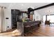 Spacious kitchen featuring a large island with seating, modern black appliances, and brick backsplash at 8708 E Rancho Vista Dr, Scottsdale, AZ 85251