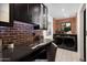 Functional laundry room with modern appliances, brick accent wall, and ample counter space at 8708 E Rancho Vista Dr, Scottsdale, AZ 85251