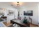 Well-lit home office with a contemporary chandelier, modern desk, and sleek, wall-mounted television at 8708 E Rancho Vista Dr, Scottsdale, AZ 85251