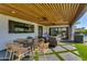 Charming covered patio with a dining table, comfortable seating, and smooth transitions to the green backyard and pool at 8708 E Rancho Vista Dr, Scottsdale, AZ 85251