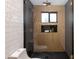 Elegant walk-in shower with black and white patterned tiles, gold shower fixtures, and a glass door at 8708 E Rancho Vista Dr, Scottsdale, AZ 85251