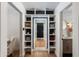 Bright walk-in closet with custom shelving, a full-length mirror, and hardwood floors leading to the bathroom at 8708 E Rancho Vista Dr, Scottsdale, AZ 85251