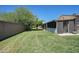 Backyard with a large grassy lawn, tree, and walled fence line at 10018 N 97Th Dr # A, Peoria, AZ 85345