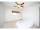 Bright bedroom featuring neutral carpet, a ceiling fan, and a sunny window at 10018 N 97Th Dr # A, Peoria, AZ 85345