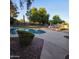 Beautiful backyard featuring a sparkling blue pool, lush landscaping, and comfortable seating area at 1032 E Sheffield Ave, Chandler, AZ 85225