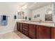 Bathroom featuring a double sink vanity with framed mirrors and ceramic tile flooring at 10412 W Cottontail Ln, Peoria, AZ 85383