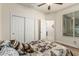 Inviting bedroom showcasing a ceiling fan, window, and a view of a partially opened bathroom at 10412 W Cottontail Ln, Peoria, AZ 85383