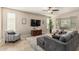 Comfortable living room featuring neutral tones, a large TV, a ceiling fan, and stylish furnishings at 10412 W Cottontail Ln, Peoria, AZ 85383