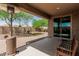 Covered patio with sliding glass door, brick accents, and a view of the landscaped backyard at 10412 W Cottontail Ln, Peoria, AZ 85383