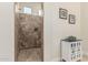 Tiled walk-in shower with glass surround, decorative accents, and a built-in shower head at 10412 W Cottontail Ln, Peoria, AZ 85383