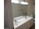 Bathroom vanity with double sinks, matching mirror, and updated lighting fixture at 1044 N Abner --, Mesa, AZ 85205