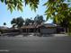 Street view of single-story home featuring mature shade trees, tile roof, and two car garage at 1044 N Abner --, Mesa, AZ 85205
