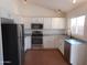 Updated kitchen boasts white cabinets, stainless steel appliances, and tile floors at 1044 N Abner --, Mesa, AZ 85205