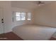 Bright living room featuring vaulted ceilings, neutral carpeting, and ample natural light from large windows at 1044 N Abner --, Mesa, AZ 85205