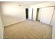 A bright bedroom features neutral walls and carpet with a closet and open door to another room at 10828 N Biltmore Dr # 133, Phoenix, AZ 85029