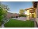 Beautiful backyard featuring artificial grass, brick patio, privacy wall, and desert landscaping at 13330 W Milton Dr, Peoria, AZ 85383