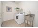 Well-lit laundry room featuring a modern washer and dryer, stainless steel sink, and ample shelving space at 13330 W Milton Dr, Peoria, AZ 85383