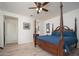 This main bedroom features a four poster bed, ceiling fan and an ensuite bathroom at 13330 W Milton Dr, Peoria, AZ 85383