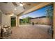 Covered patio with ceiling fans transitions to a brick paver patio with outdoor seating and manicured backyard at 13330 W Milton Dr, Peoria, AZ 85383
