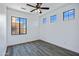 Bright bedroom with wood-look floors, a ceiling fan, and two windows with a view at 1367 S Country Club Dr # 1221, Mesa, AZ 85210