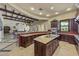 Elegant kitchen featuring a large island, granite countertops, dark wood cabinets, and an open view to the living area at 1367 S Country Club Dr # 1221, Mesa, AZ 85210