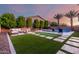 Spacious backyard with pool, patio seating, putting green, and artificial turf at 14481 W Via Del Oro --, Surprise, AZ 85379