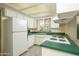 Kitchen showcasing white cabinetry, green countertops, and white appliances at 1541 E Glencove St, Mesa, AZ 85203