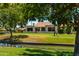 Charming single-story home featuring a tile roof, lush landscaping, and water views at 156 Leisure World --, Mesa, AZ 85206