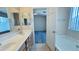 Bright bathroom featuring a dual sink vanity, a tub, and a doorway to the Primary bedroom at 1630 W Pecan Rd, Phoenix, AZ 85041
