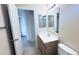 Modest bathroom with a single sink vanity, mirror, and tile flooring leading to open door at 1630 W Pecan Rd, Phoenix, AZ 85041