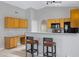 Open kitchen with oak cabinets, breakfast bar, black appliances, and bright lighting at 16417 S 43Rd Pl, Phoenix, AZ 85048