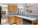 Corner kitchen view with oak cabinets, a corner sink, and view into the living space at 16417 S 43Rd Pl, Phoenix, AZ 85048