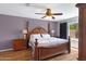 Main bedroom with a decorative wooden bed frame, wood floors and a ceiling fan at 16417 S 43Rd Pl, Phoenix, AZ 85048
