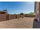 Spacious backyard featuring a stone ground cover, mature landscaping, and a privacy fence at 18297 W Spencer Dr, Surprise, AZ 85374