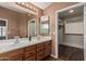 Bathroom featuring double sinks, wooden drawers, and a large mirror at 18297 W Spencer Dr, Surprise, AZ 85374